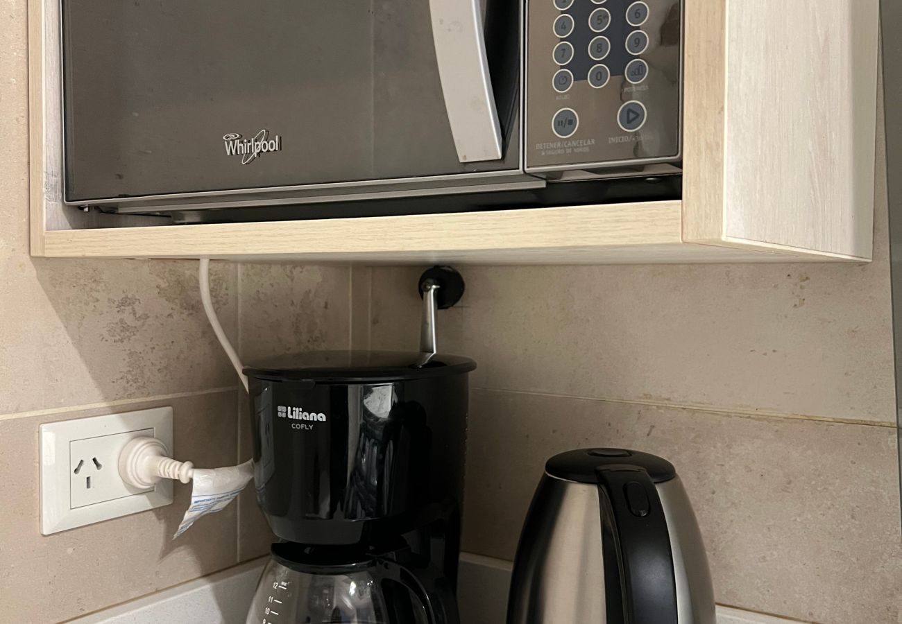 Detalhe da cozinha do apartamento Arrayán -1A com micro-ondas, chaleira elétrica e cafeteira de filtro.