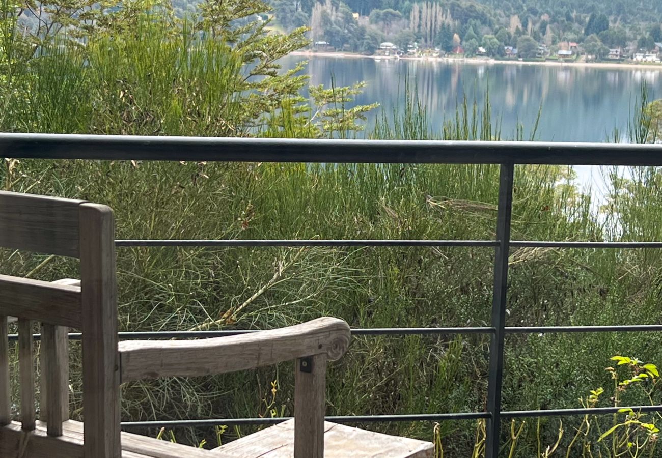 Detalhe da varanda do apartamento Arrayán 1A com mobiliário externo e vista panorâmica para o lago.